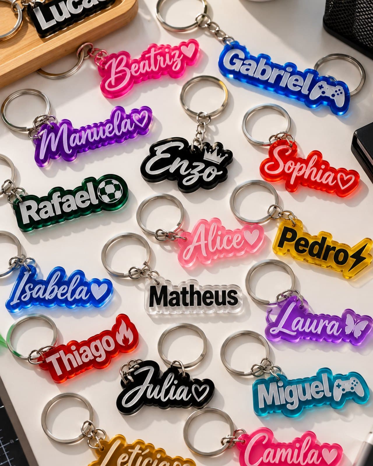 Chaveiros de acrílico coloridos com nomes, espalhados sobre a mesa