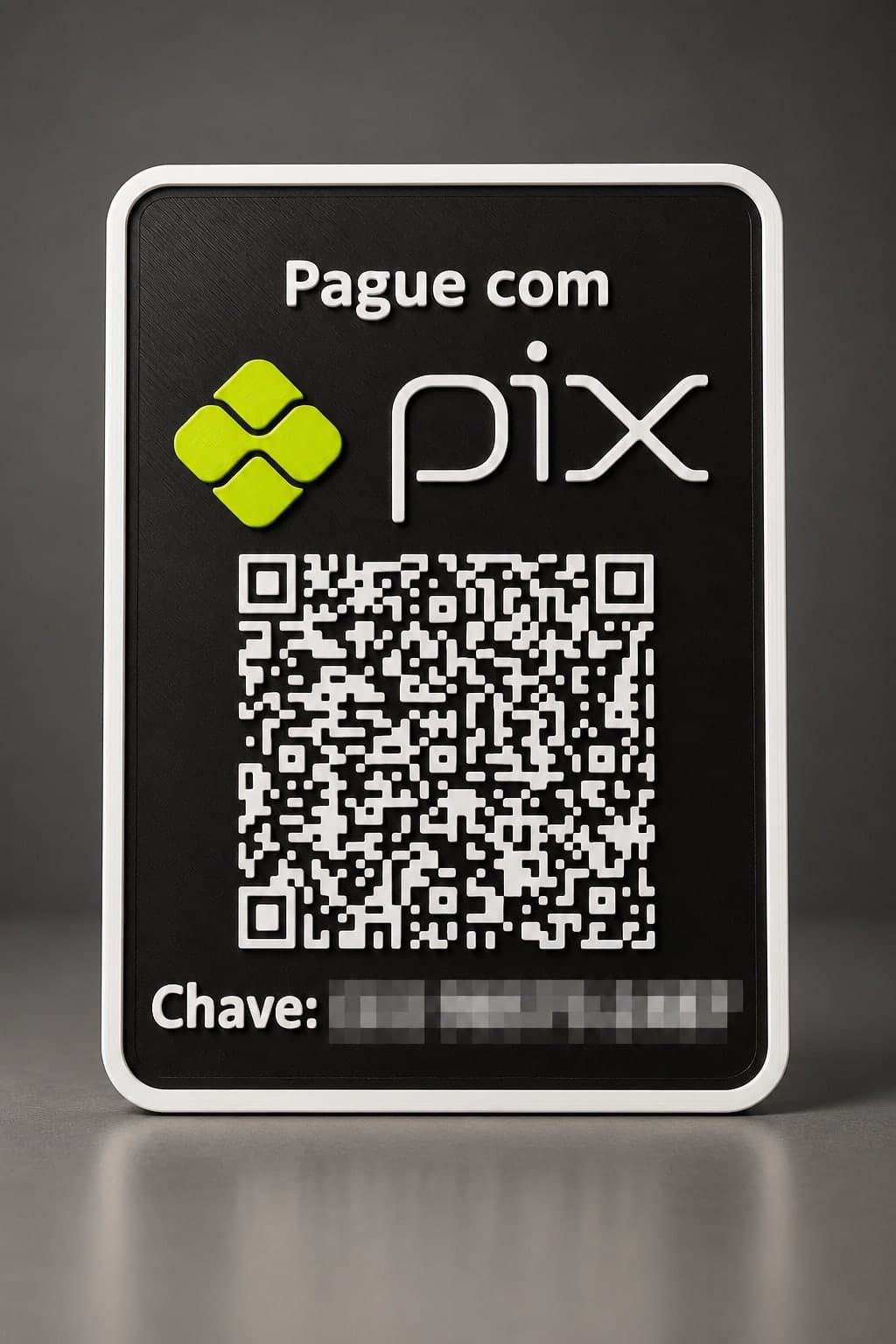 Plaquinha preta impressa em 3D com “Pague com Pix”, QR Code e chave em relevo branco, segurada na mão